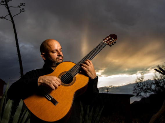José Luis Puerta ’09 ’16 playing guitar