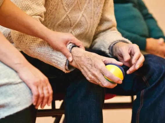 closeup of an older person holding a small ball