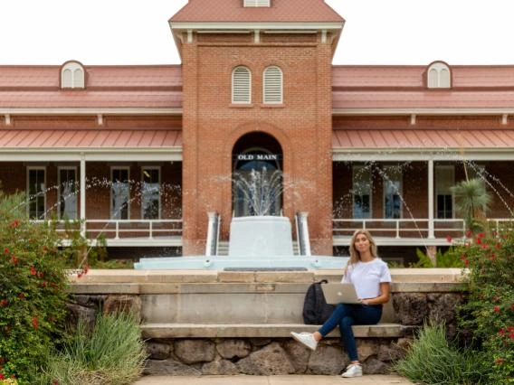 student in front of old main