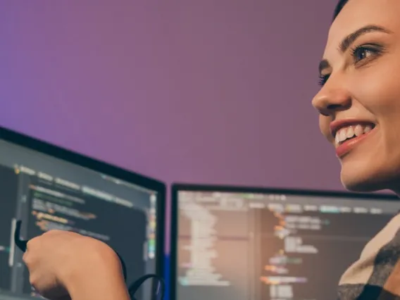 A photograph of an enthusiastic woman in a computer lab.