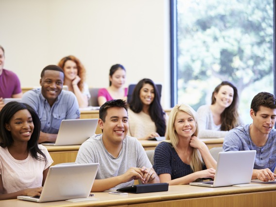 A photograph of students sitting and smiling in class 