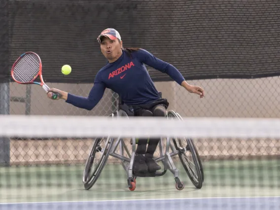 A photograph of a man about to hit a tennis ball