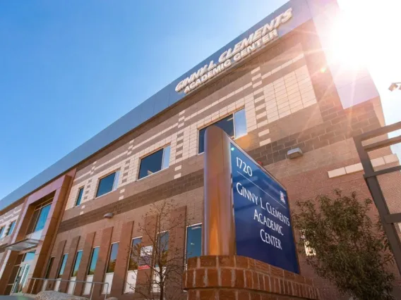 A photograph of the Ginny L. Clements Academic Center with the sun shining in the background 