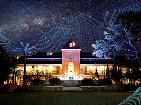 A photograph of Old Main at night with digital lines surrounding it