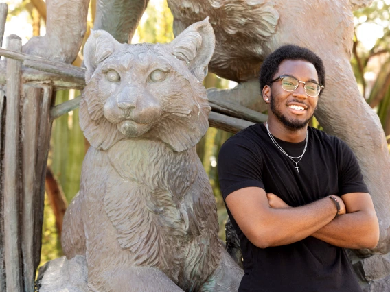 Daryl Ijaola standing next to the Wildcat statue