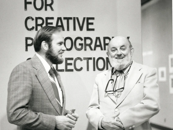 Two men smiling in front of The Center for Creative Photography entrance
