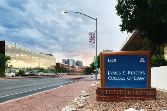 A photograph of the James E. Rogers College of Law signage, onlooking the street