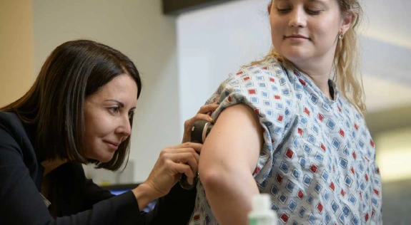 A photograph of a woman being examined by a doctor