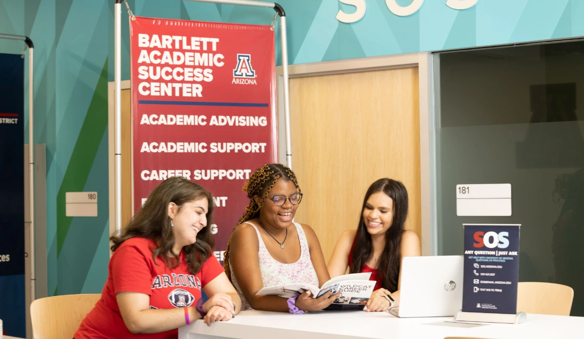 Group of students sitting at a table and laughing