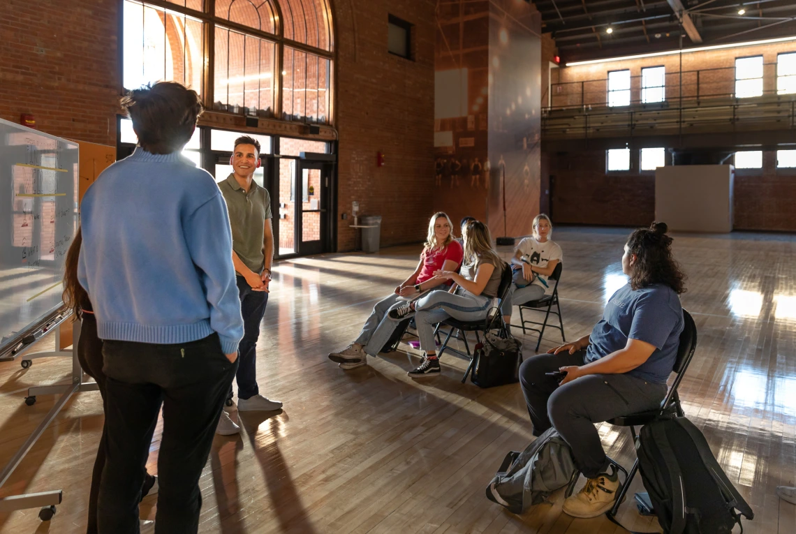 Students and faculty presenting in sun filled room