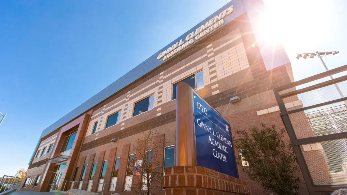 A photograph of the Ginny L. Clements Academic Center with the sun shining in the background 