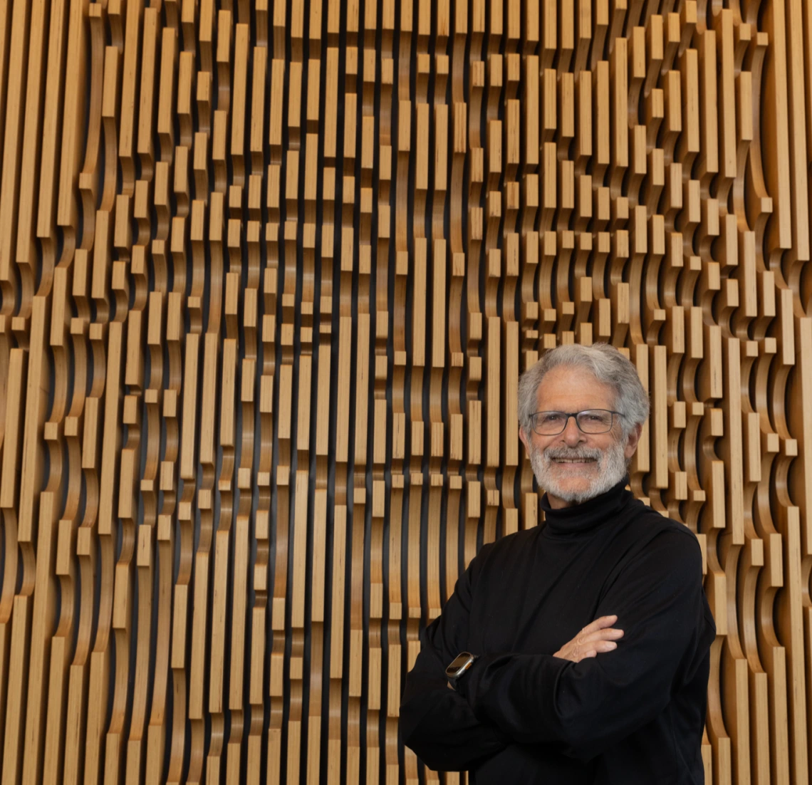 John Lee Compton standing in front of the Wildcat wall at the W.A. Franke Honors College