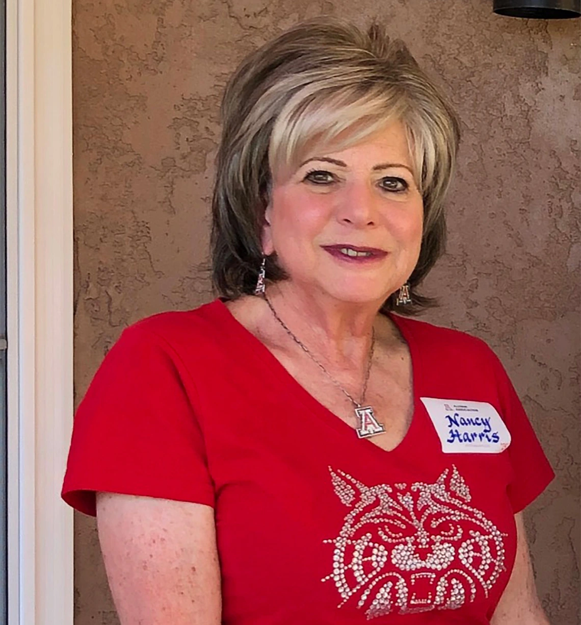 Nancy Harris wearing a red Wildcat shirt smiling 