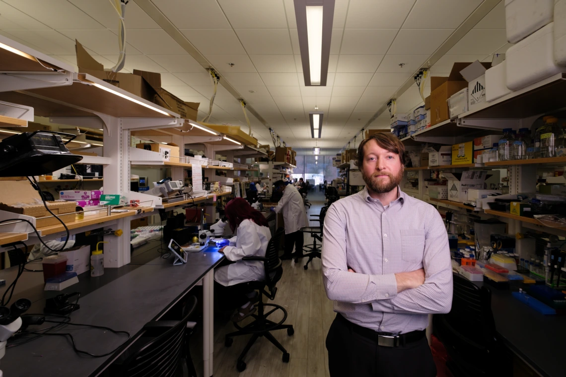 An Image of Phillipp Gutruf, standing facing the camera with his arms crossed, in the Gutruf Lab where biomedical sensors for inside and outside the body. are developed.