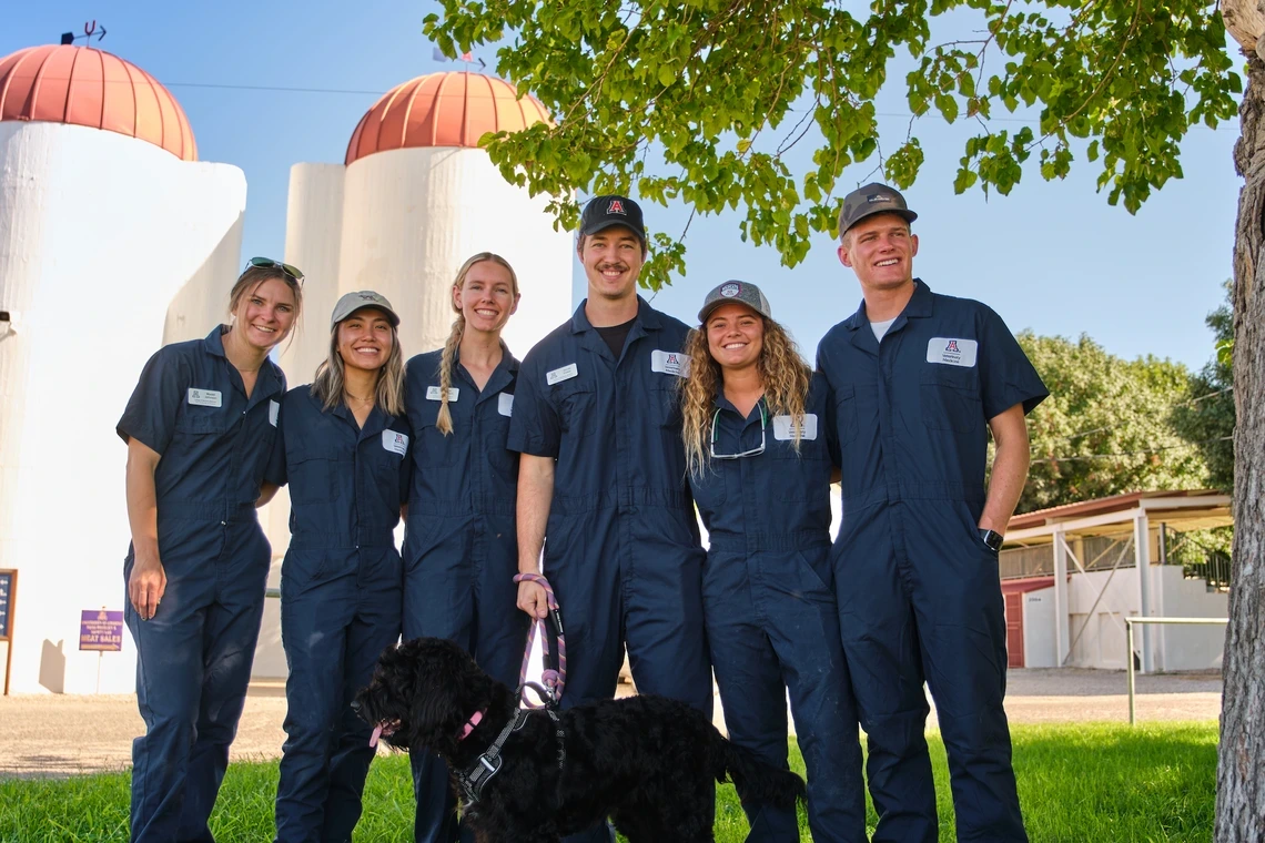 Veterinary students smiling arm-in-arm.