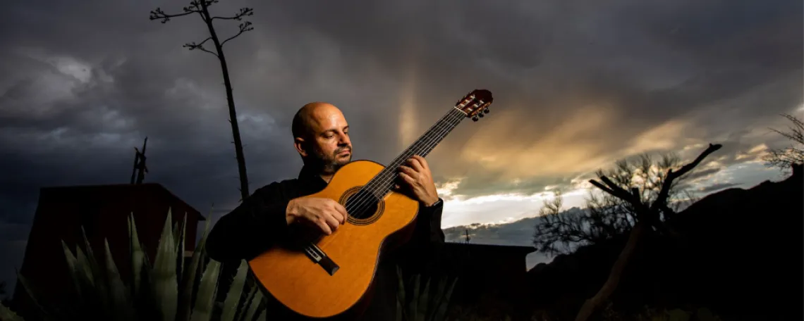 José Luis Puerta ’09 ’16 playing guitar