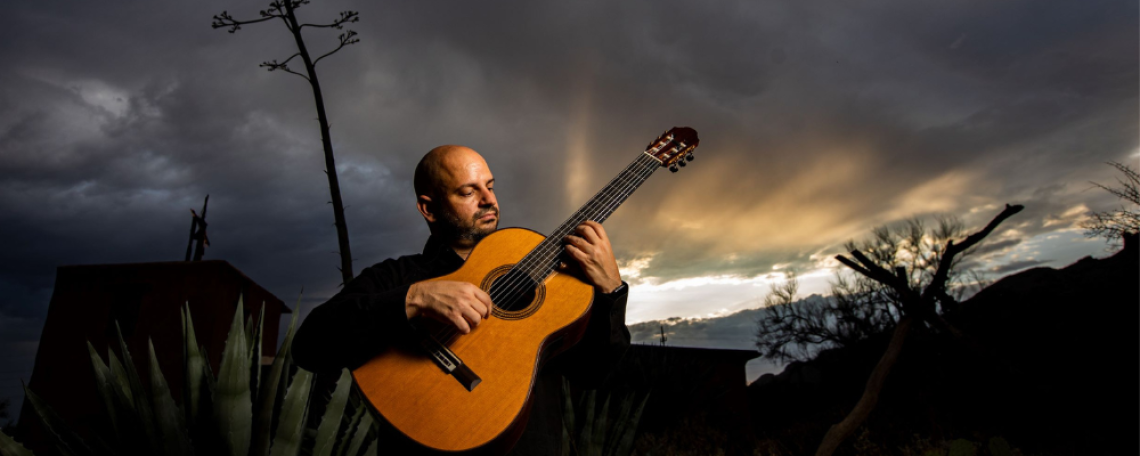 José Luis Puerta ’09 ’16 playing guitar