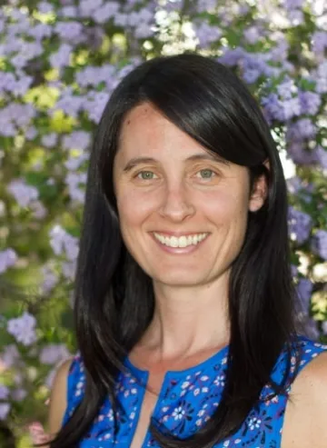 A woman in a blue top smiling