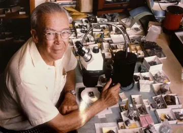 Arthur Roe looking up and smiling with his mineral collection