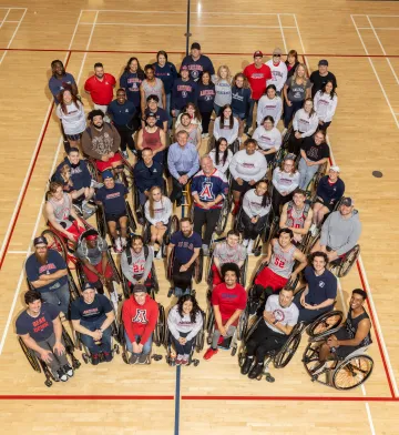 Click (center) gathers with adaptive student-athletes, coaches, alumni, support staff and parents to celebrate Clicks' $6.5 million gift to the program.