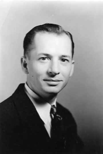 Glen McPherren smiling in a black and white portrait