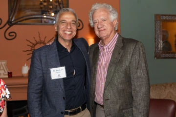 Dr. Hesham Sadek standing arm in arm with Humberto Lopez, smiling